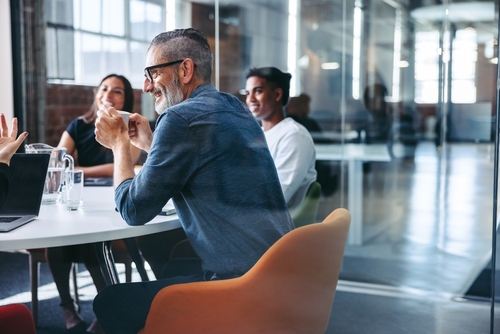 Happy,Mature,Businessman,Attending,A,Meeting,With,His,Colleagues,In